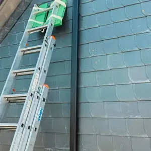Leiter am Schieferdach für Reparaturarbeiten
